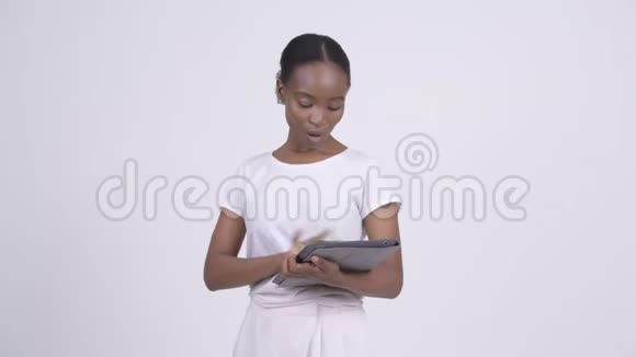 快乐年轻美丽的非洲女人用数码平板电脑说话视频的预览图