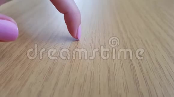 女性手指白色皮肤粉红色短指甲抓着木桌视频的预览图