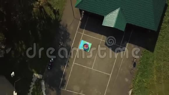 有绿色屋顶大型场地和彩色球环绕的小游泳池的休闲中心的空中景观视频的预览图