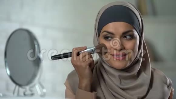 自信的阿拉伯女人化妆用刷子涂粉女性化视频的预览图