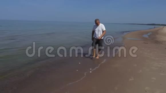 在海边的人展示收集贝壳视频的预览图