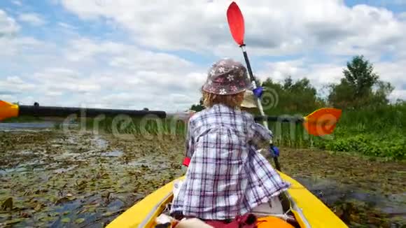 一个小孩用皮划艇划桨积极的家庭度假视频的预览图
