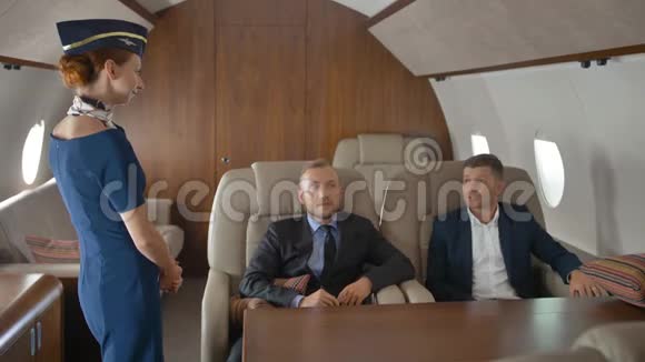 企业家在私人飞机上放松飞行和与空姐交谈视频的预览图