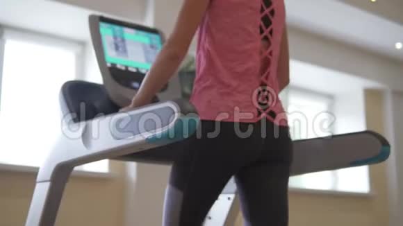 年轻性感的女人在大厅里的模拟跑步机上跑步视频的预览图
