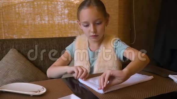 寿司店十几岁的女孩在桌上卷起湿漉漉的棉布餐巾视频的预览图