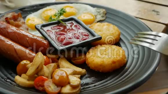 女人吃传统的英式早餐包括煎鸡蛋香肠红豆土豆蘑菇和西红柿关闭视频的预览图