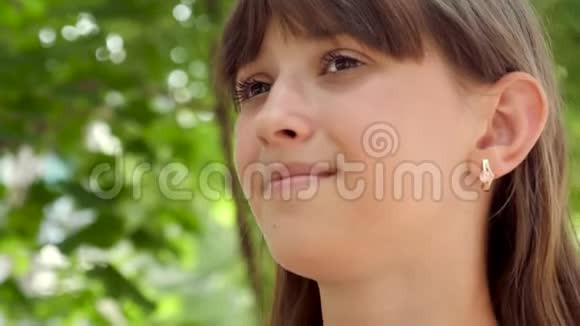 女孩正在从城市公园的稻草中喝美味的奶昔特写视频的预览图