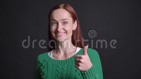 有着迷人的白种人女性特写镜头红色的头发和灰色的眼睛微笑着拇指朝上视频的预览图