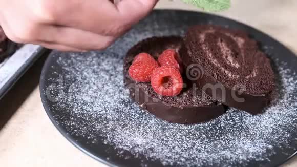 厨师布置和装饰切碎的瑞士巧克力卷用覆盆子装饰的瑞士卷视频的预览图