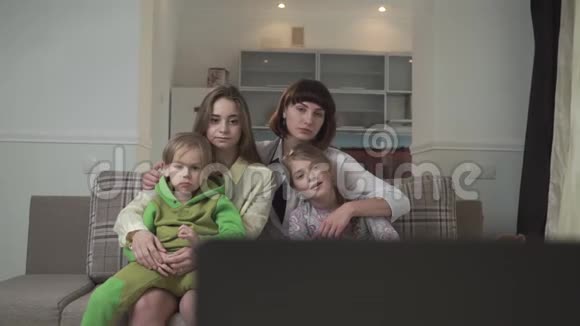 一家人坐在客房的沙发上看电视因为不好姐姐们把眼睛闭到孩子身上视频的预览图