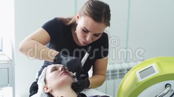 美容师在病人脸上做液压剥离和清洁程序面部皮肤剥落视频的预览图