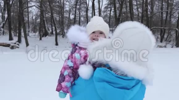 在寒冷的冬天我妈妈手里的宝贝在白雪上散步母亲带着孩子在大自然中散步圣诞节视频的预览图