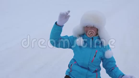 快乐的女孩从雪山上滚来滚去笑了起来女人在冬天雪橇微笑着圣诞节视频的预览图