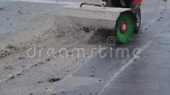 用毛刷扫雪机清扫道路上的脏雪的人视频的预览图