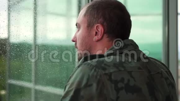 前军人站在窗边下雨了视频的预览图
