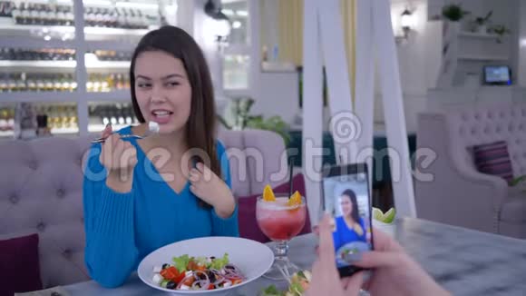 素食妇女的肖像手拿新鲜有用的沙拉午餐时在手机上为社交媒体拍照视频的预览图