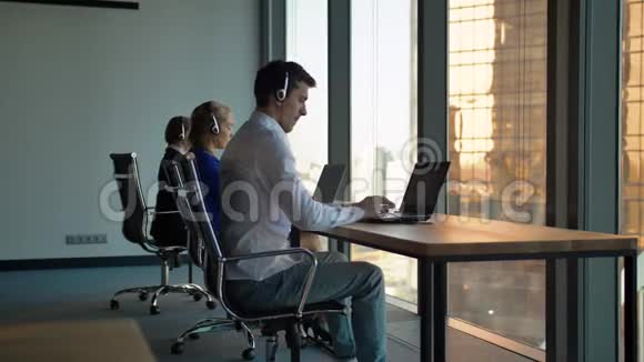 呼叫中心的工作人员在办公室的办公桌上打字视频的预览图