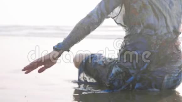 年轻的湿身体操运动员在沙滩上翻水的肖像视频的预览图