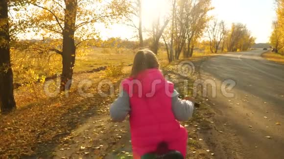 女孩在公园里学骑自行车骑运动自行车儿童健康生活方式的概念视频的预览图