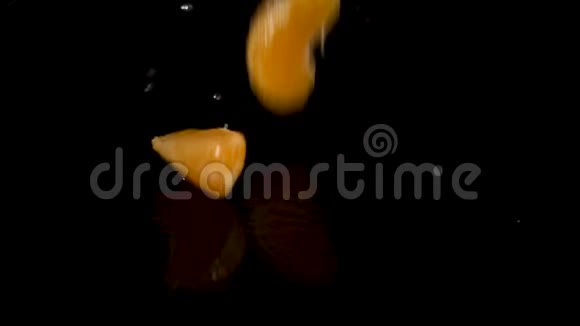 鲜橙柑桔的鱼在黑色的背景上缓慢地落入水中视频的预览图