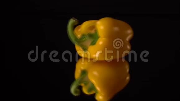 鲜黄胡椒在黑镜桌上分离或爆炸黑色背景视频的预览图