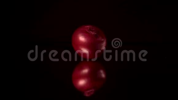 新鲜的红洋葱在镜子上旋转或镜面黑色桌子与黑色背景视频的预览图