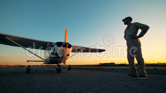 飞行员站在飞机附近的跑道上靠近视频的预览图