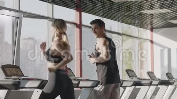 健身中心跑步机上的夫妇训练有氧运动视频的预览图