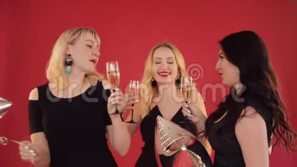 快乐积极的女人带着一杯香槟在红色背景上跳舞视频的预览图