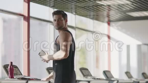 在健身俱乐部的跑步机上行走的帅哥视频的预览图