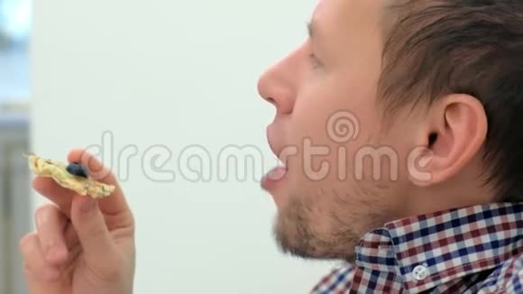 男人正在吃一片披萨侧视面部特写视频的预览图