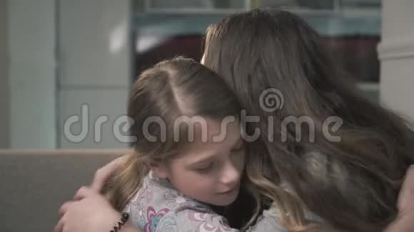 两个姐妹紧紧拥抱在一起小女孩和大女孩擦鼻子姐妹关系视频的预览图