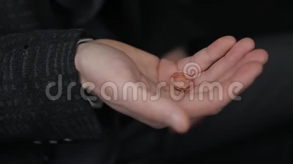 一个男人手里捏着两枚结婚戒指特写视频的预览图