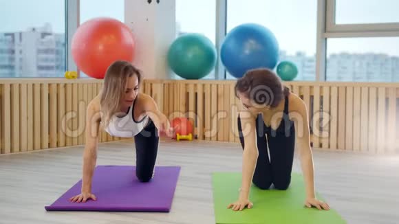 年轻女性在瑜伽垫上的工作室里做瑜伽锻炼腿保持平衡视频的预览图