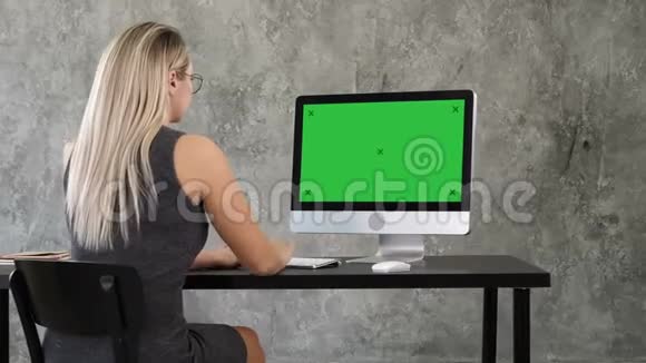 女商人在创意办公室使用台式电脑绿色屏幕模拟显示视频的预览图