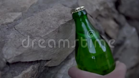 一个男人打开一瓶碳酸饮料撞到路边金属盖子玻璃瓶视频的预览图