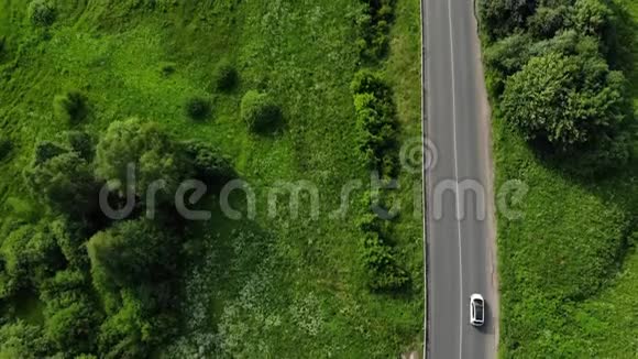 绿色森林中的道路空中镜头几辆汽车在高速公路上行驶汽车在绿色的柏油路上行驶视频的预览图