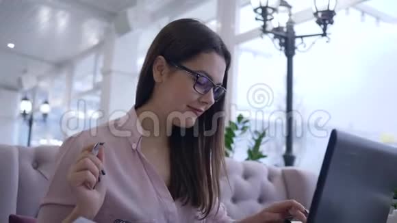 现代支付技术成功的自由职业者女性使用笔记本电脑用信用卡支付互联网服务视频的预览图