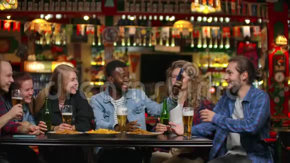 朋友在酒吧手机拍照在手机上做一张分享照片在酒吧和朋友一起喝啤酒视频的预览图