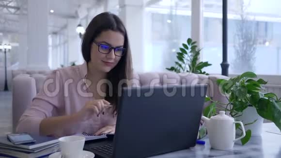 现代智能技术快乐成功的女性在笔记本电脑工作时用手机拍照视频的预览图
