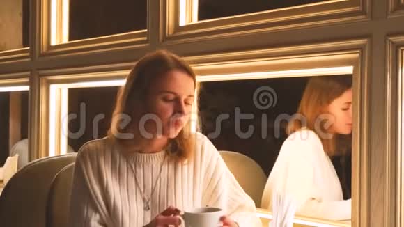 迷人的现代年轻女性在咖啡厅喝芳香咖啡视频的预览图