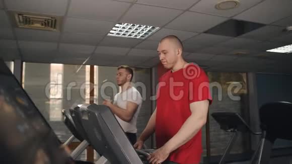 男人在健身房的跑步机上做运动视频的预览图