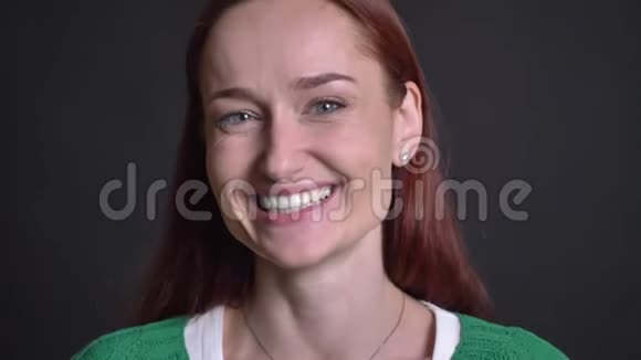 有着红发的白种人迷人的女性特写镜头笑着抬头然后直视镜头视频的预览图