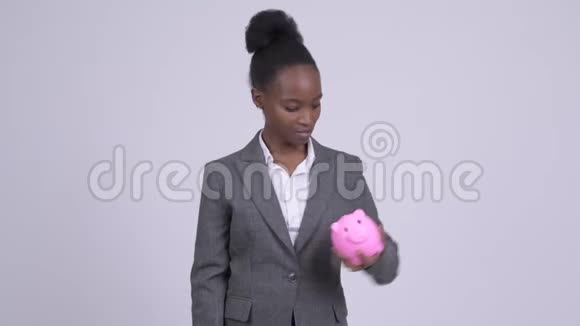 年轻悲伤的非洲女商人拿着储蓄罐竖起大拇指视频的预览图