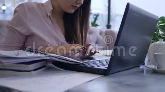 在线支付学生女孩在远程学习期间使用笔记本电脑并用塑料卡支付教育费用视频的预览图