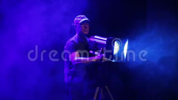 舞台上的一个人用一台戏剧放映机拍摄烟雾中的光线视频的预览图