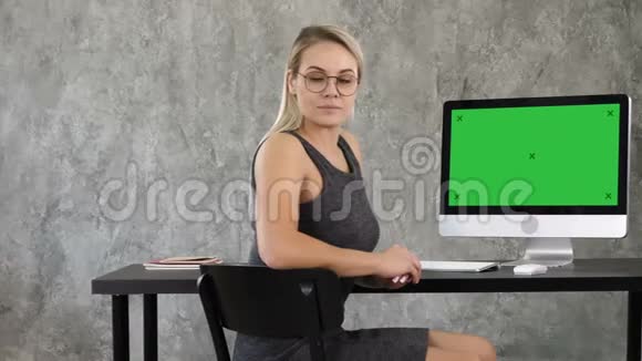 傲慢的自由职业女性在办公室摆姿势看着你查看到计算机屏幕绿色屏幕模拟显示视频的预览图