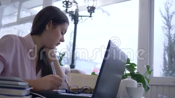 困乏疲惫的女学生利用现代计算机技术在网上备课视频的预览图