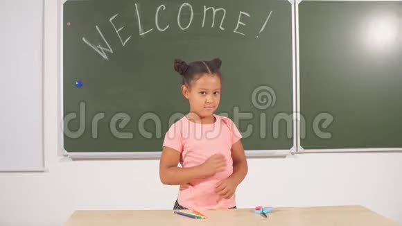 非洲女孩在黑板上摆姿势教室里的黑人女学生视频的预览图