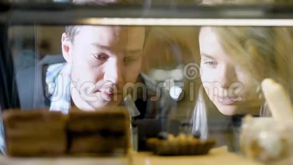 通过展示一对夫妇看糖果和选择在面包店外面吃饭视频的预览图